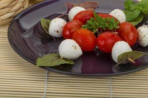 ensalada caprese en el plato y fondo de madera foto