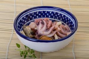 Seafood cocktail in a bowl on wooden background photo