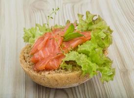 Salmon sandwich with thyme on wooden background photo