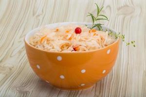 Sauerkraut in a bowl on wooden background photo