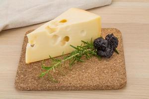 Cheese maasdam on wooden board and wooden background photo