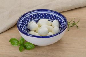 Mozzarella cheese in a bowl on wooden background photo