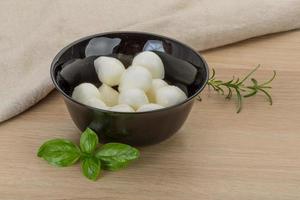 Mozzarella cheese in a bowl on wooden background photo