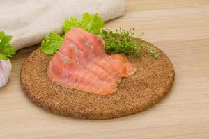 Sliced salmon on wooden board and wooden background photo