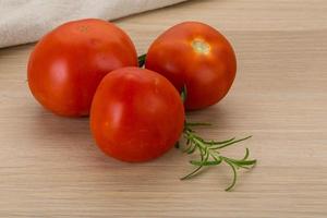 Fresh tomatoes on wooden background photo