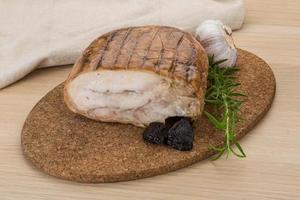 Turkey roll on wooden board and wooden background photo