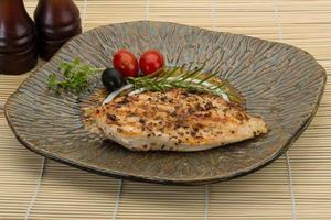 Grilled chichen breast on the plate and wooden background photo