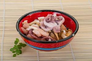 Seafood cocktail in a bowl on wooden background photo