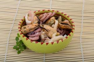 Seafood cocktail in a bowl on wooden background photo