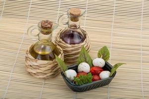 Caprese salad in a bowl on wooden background photo