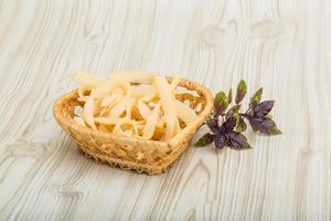 Dry calamari in a basket on wooden background photo