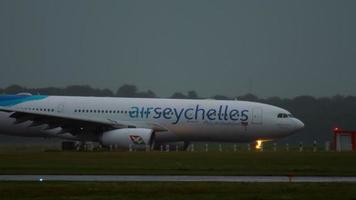 Dusseldorf, Duitsland 24 juli 2017 - Air Seychellen Airbus 330 S7 Vdm taxiën na de landing in de vroege ochtend bij regen. dusseldorf luchthaven, duitsland video