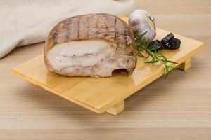 Turkey roll on wooden board and wooden background photo