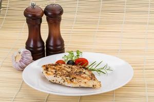 Grilled chichen breast on the plate and wooden background photo