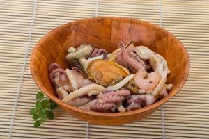 Seafood cocktail in a bowl on wooden background photo