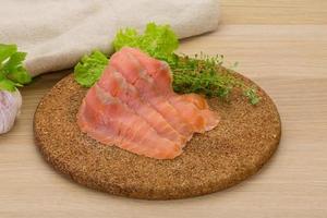 Sliced salmon on wooden board and wooden background photo