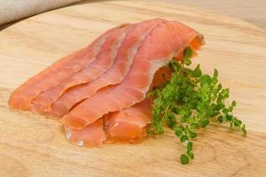 Sliced salmon on wooden board and wooden background photo