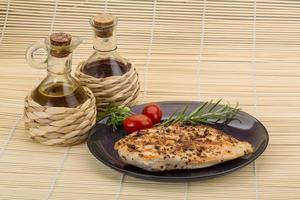 Grilled chichen breast on the plate and wooden background photo