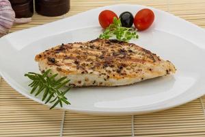 Grilled chichen breast on the plate and wooden background photo