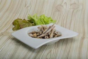 Dries anchovy in a bowl on wooden background photo