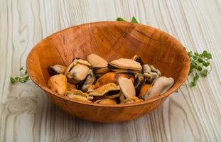 Mussels in a bowl on wooden background photo