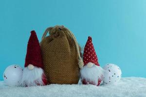 gnomos navideños con regalos alrededor del árbol de navidad. bolsa mágica. bosque de pinos. Feliz Navidad. foto