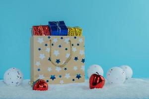 bolsa de papel con regalos de pie sobre la nieve.concepto de invierno. Feliz Navidad. foto