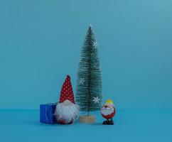 santa claus y gnomo de navidad alrededor del árbol de año nuevo con regalos. Feliz Navidad. foto