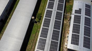 Aerial view of Solar panels installed on a roof of a large industrial building or a warehouse. Top view of solar power station with factory. sustainable energy concept. photo
