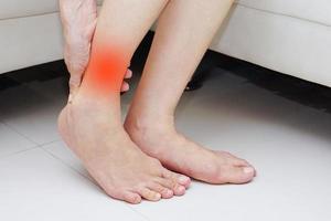 Woman suffering from ankle pain. Medical and health concept. photo