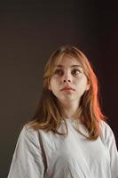 portrait of a girl in a white T-shirt on a dark background photo