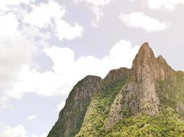 The steep mountain cliff overlooking the sky and white clouds. photo