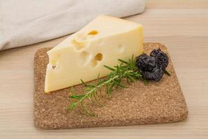 Cheese maasdam on wooden board and wooden background photo