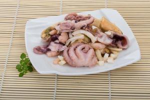 Seafood cocktail on the plate and wooden background photo