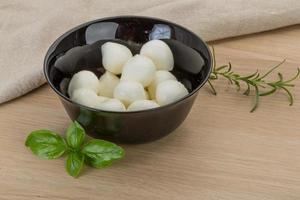 Mozzarella cheese in a bowl on wooden background photo