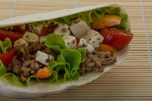 Pork tortilla on wooden background photo