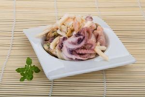 Seafood cocktail in a bowl on wooden background photo