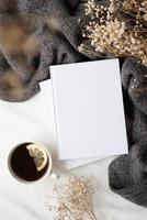white blank books with gray plaid, cup of lemon tea and dry flowers , mockup design photo