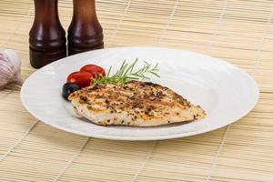 Grilled chichen breast on the plate and wooden background photo