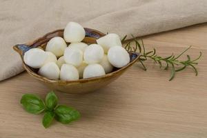 Mozzarella cheese in a bowl on wooden background photo