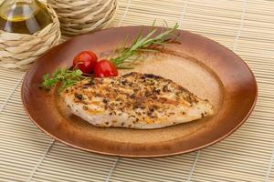 Grilled chichen breast on the plate and wooden background photo