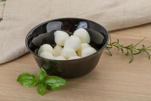 Mozzarella cheese in a bowl on wooden background photo