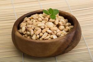 Peanut in a bowl on wooden background photo