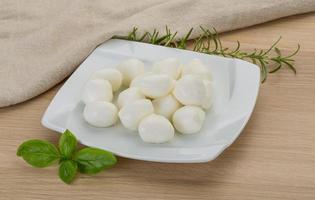 Mozzarella cheese on the plate and wooden background photo