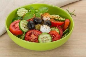 ensalada con mozzarella y tomates en un bol sobre fondo de madera foto