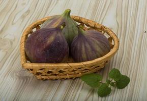 Figs in a basket on wooden background photo