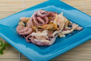 Seafood cocktail on the plate and wooden background photo