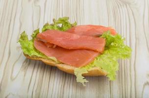 Salmon sandwich on wooden background photo