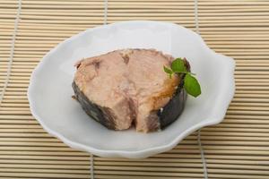 Canned tuna on the plate and wooden background photo