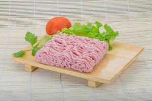 Raw minced pork meat on wooden board and wooden background photo